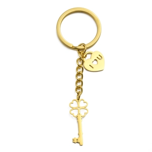 Golden stainless steel four-leaf clover key and heart lock pendant keychain on white background