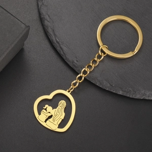 Détail d'un porte-clés cœur en acier inoxydable doré avec silhouette mère et enfant