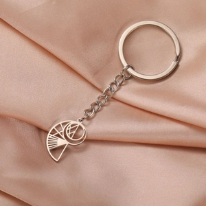 Macro shot of a hollow nautilus shell pendant keychain on champagne silk fabric background