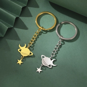 Detailed macro view of planet, moon and star charms on polished metal keychains