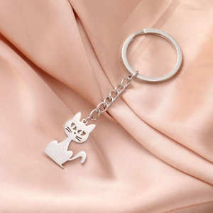 Polished stainless steel cat shape keychain with cutout details on pink silk background