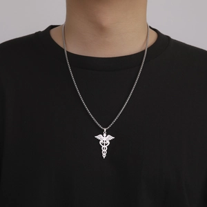 Polished stainless steel Caduceus medical pendant necklace on black t-shirt