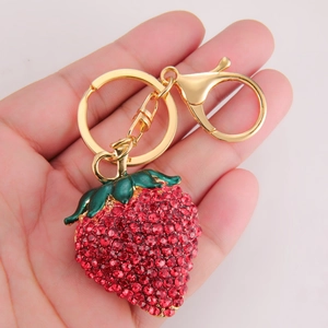 Porte-clés fraise étincelant avec cristaux rouges et alliage doré en main
