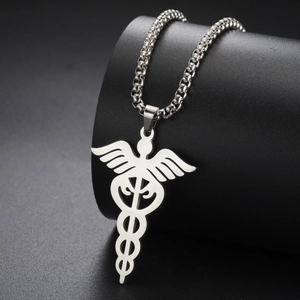 Detailed close-up of a silver stainless steel caduceus pendant on a black pedestal