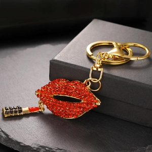 Détail d'un porte-clés lèvres en strass rouges avec un mini charme rouge à lèvres doré