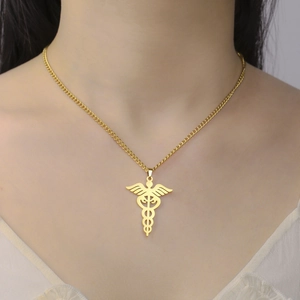 Detail of gold Caduceus medical pendant on a stainless steel chain worn by a model
