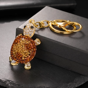 Macro shot of rhinestone turtle keychain with sparkling gold metal and amber crystals