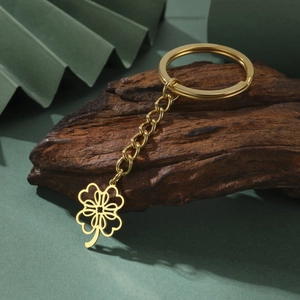 Elegant gold clover pendant keychain on wooden base with minimalist stainless steel link chain