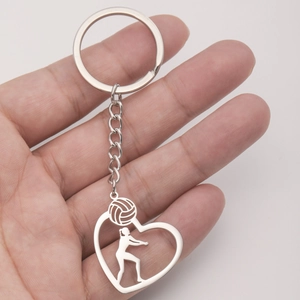 Portachiavi lucido a forma di cuore con silhouette di pallavolista tenuto in mano