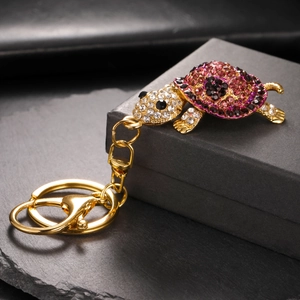 Detail of creative rhinestone turtle keychain with pink gradient crystals and gold clasp