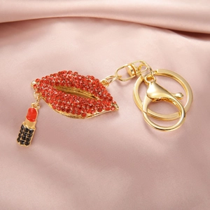 Détail d'un porte-clés lèvres en strass rouges avec un petit pendentif rouge à lèvres