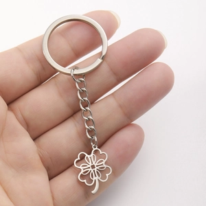Minimalist stainless steel keychain featuring a hollow clover heart pendant in hand