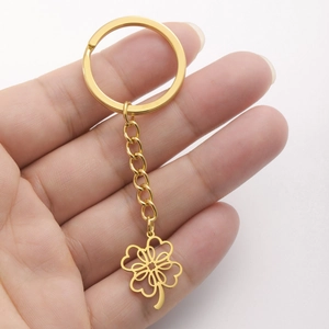 Detailed close-up of golden stainless steel four-leaf clover keychain pendant with keyring