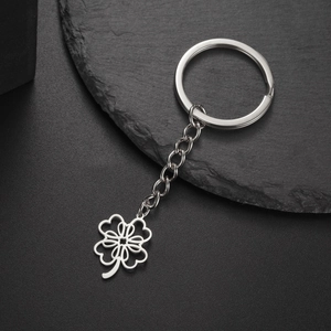 Detailed macro view of silver stainless steel keychain featuring a hollow clover leaf pendant