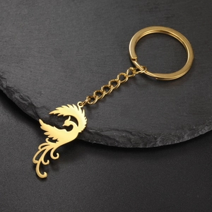 Detailed close-up of a golden phoenix charm with polished finish on a steel keychain