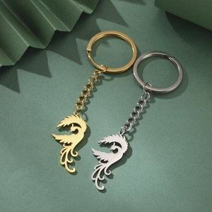 Detailed view of phoenix pendants in gold and silver stainless steel with keychains