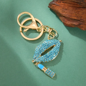 Détail du porte-clés lèvres strass bleu avec pendentif rouge à lèvres et fermoir doré