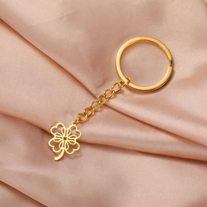 Detail of a gold stainless steel keychain with a hollow four-leaf clover heart pendant