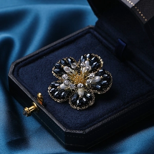 Elegante bloembloesem met zwart-witte kristallen op gouden basis in een geschenkdoos