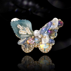 Elegant butterfly brooch with light blue petals, white pearls and crystals on gold base