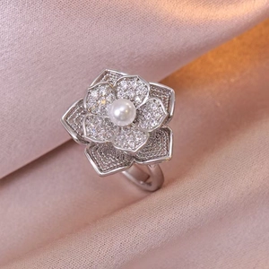 Detailaufnahme eines silbernen Blumenrings mit weißer Perle und funkelnden Zirkonen