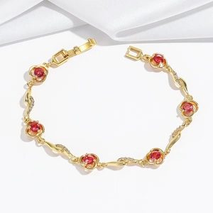Elegante bracciale a fiori dorato con pietre rosse e zirconi bianchi sulla seta