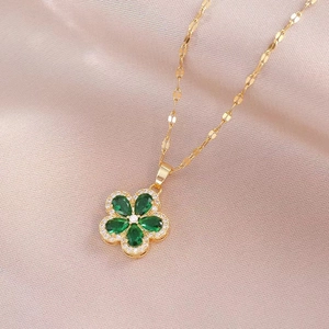 Collier en or élégant avec pendentif fleur en zircon vert émeraude sur tissu de soie champagne