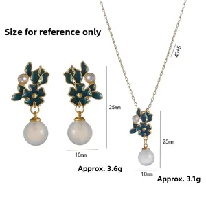 Vintage gold jewelry set with green enamel flowers and pearl pendants on white background