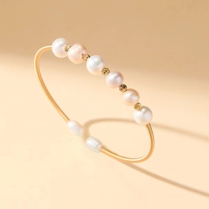 Eleganter goldener Spiral-Armreif mit natürlichen weißen, rosa und lila Perlen für Damen