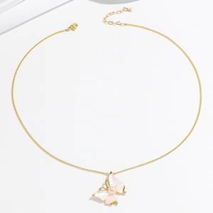 Elegant gold butterfly necklace with shell wings and pink pearl on white background