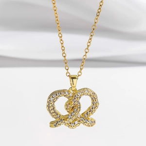 Elegante collana a fiocco cuore dorato con pavé di zirconi scintillanti su fondo morbido