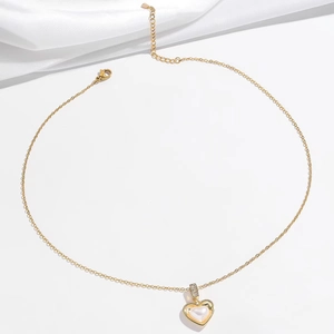 Golden heart pendant necklace with pearl inlay and zircon accents on a gold link chain