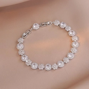 Primer plano de pulsera de plata con circonitas sobre una elegante tela de seda champán
