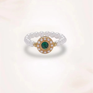 Detailaufnahme des smaragdgrünen Rings mit weißen Perlen und goldener Fassung im Vintage-Stil