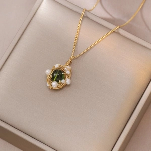 Elegante collana dorata con ciondolo a nido dotato di pietra verde e perle bianche