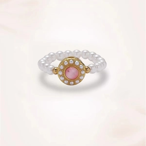 Handgefertigter Perlenring mit goldenem Ornament und einem zentralen rosa Edelstein