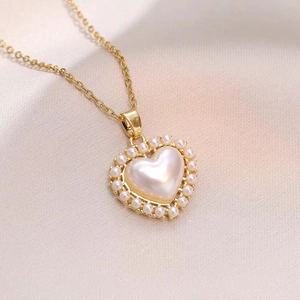 Collier élégant en forme de cœur en perle dorée sur fond de satin de champagne