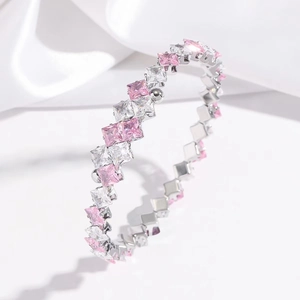 Detail of silver bangle with square cut pink and white zircon stones in rows