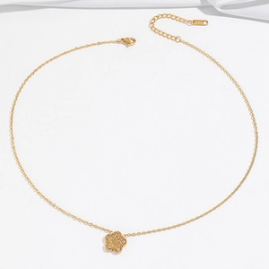 Gros plan d'un pendentif fleur dorée avec zircons brillants sur une chaîne fine