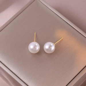 Elegante weiße Perlenohrstecker mit Vergoldung auf seidigem Schmuckkästchen-Hintergrund