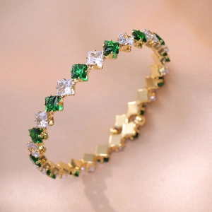 Detail eines 18K Goldarmbands mit smaragdgrünen und weißen quadratischen Zirkonia