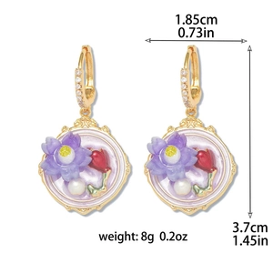Detail view of gold earrings with purple flowers and red buds with size measurements