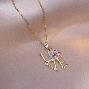 Collar LOVE dorado de moda con circonita de corazón colorida sobre fondo de seda púrpura