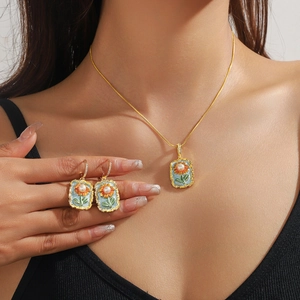 Detail eines Vintage-Schmucksets mit blauem Emaille und Perlen an einem eleganten Model
