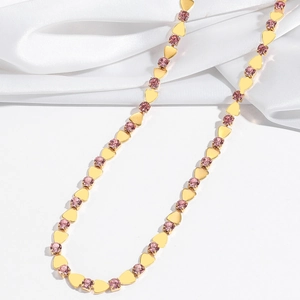 Detailed shot of golden heart links and pink zircon crystals on a titanium necklace