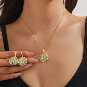 Detailansicht eines Schmucksets mit Emaille-Blumenmuster und Perlen auf einem Modell
