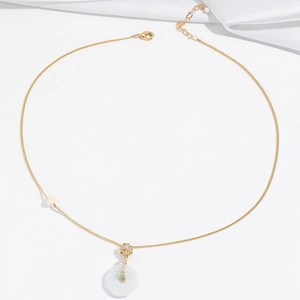 Elegante collana in titanio dorato con perla barocca e ciondolo ad anello in giada bianca