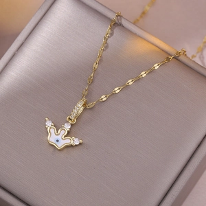 Gold crown necklace with evil eye enamel pendant on gray velvet jewelry box display