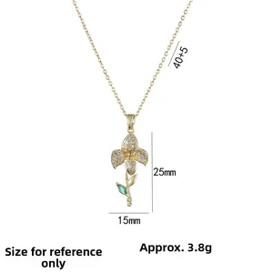 Golden flower pendant necklace with emerald green stone and sparkling zircon accents
