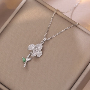 Silver flower pendant necklace with emerald green stone and white cubic zirconia accents